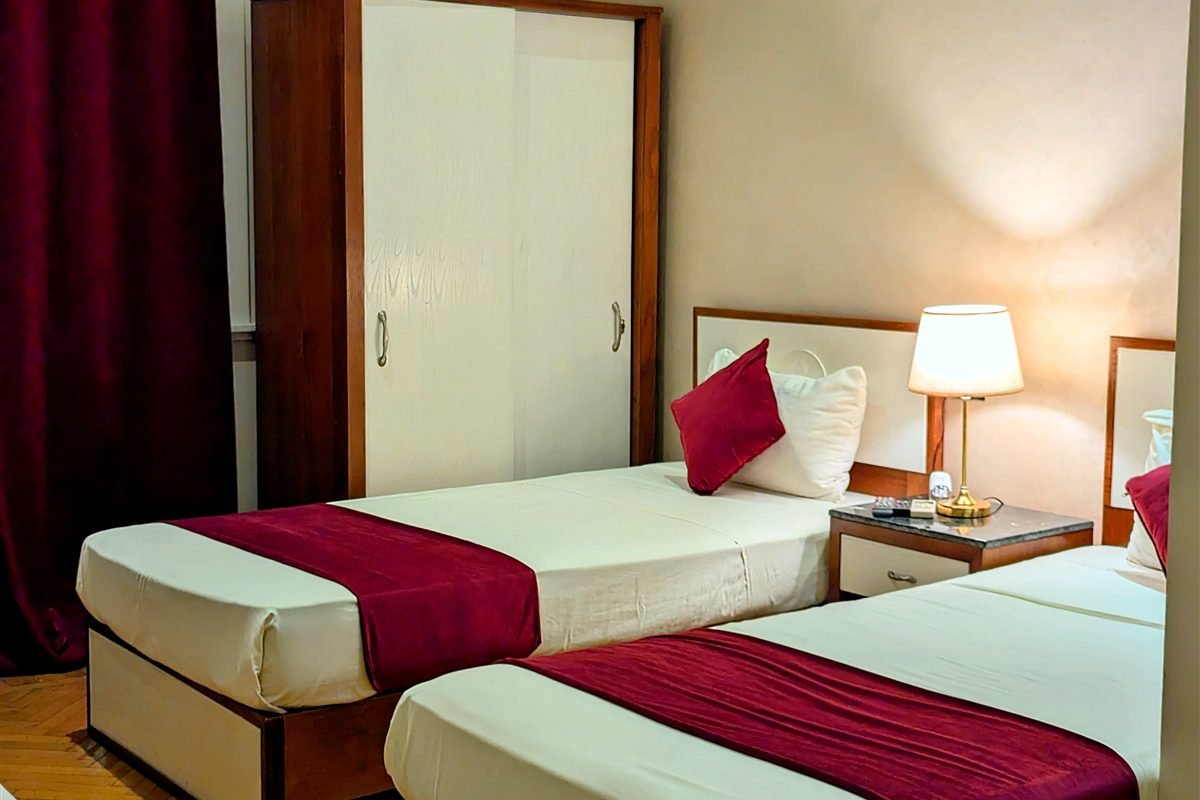 Twin room with red bed runners at Nour Hostel on Talaat Harb Street